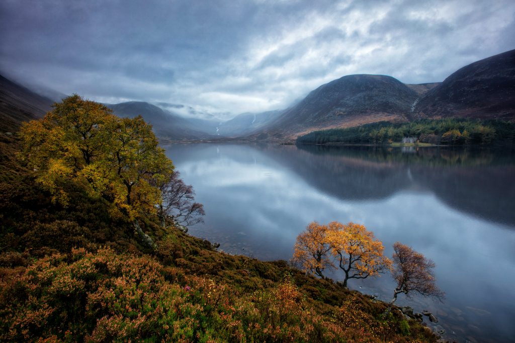 Cairngorm Mountains with an expansive loch in the foreground. Photo credit Martin Bennie via Unsplash